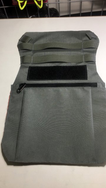 A velcro panel and zippered front pocket on this beavertail